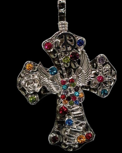 A multicolored rhinestone cross pendant with a winged guitar design and a magnetic closure.